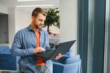 Handsome young businessman, using a laptop in the cafe