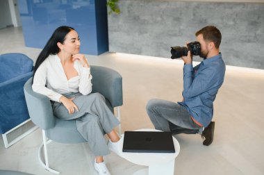 Male photographer taking picture of young woman.
