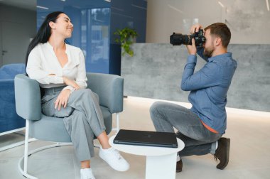 Male photographer taking picture of young woman.