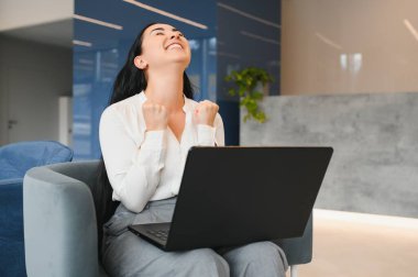 Photo of young attractive woman happy positive smile rejoice victory fists hands achievement look laptop