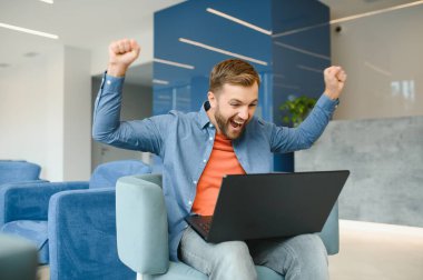 Male freelancer works with a laptop, coworking. The concept of winning and achieving success.