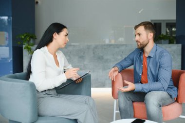 Depresyon danışmanlığı. Ofiste randevu sırasında profesyonel psikolog not alırken umutsuz bir adam mutsuz bir hayatı anlatıyor. Seçici Odaklanma.