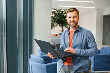 Handsome young businessman, using a laptop in the cafe