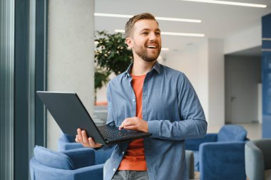 Handsome young businessman, using a laptop in the cafe