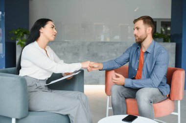 Female Psychologist, friend or family sitting and put hands on the shoulder for cheer up to mental depress man, Psychologist provides mental aid to the patient. PTSD Mental health concept