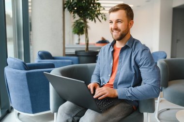 a freelancer man works with a laptop in a work coaching office.