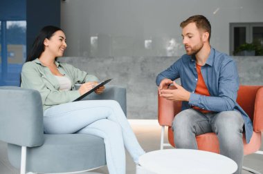 psychology, mental therapy and people concept - woman psychologist talking to sad young man patient at psychotherapy session