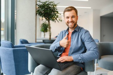 Handsome young businessman, using a laptop in the cafe