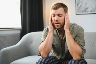 evde bir baş ağrısı olan adam.