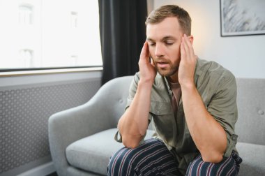 evde bir baş ağrısı olan adam.