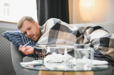 Kışın evde hava soğuktur. Kırık termostat yüzünden kışın evinde donan adam. Oturma odasındaki kanepede otururken yün ekoseye sarılı genç adam titriyor..