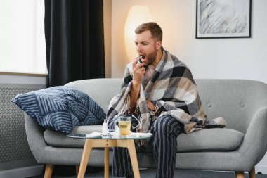 Rhinitis, ilaç ve sağlık konsepti - evde ağız spreyi kullanan hasta adam.