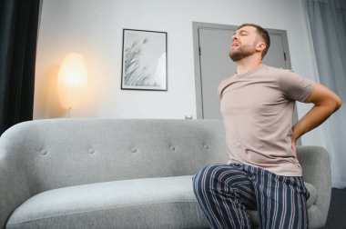 Yakışıklı genç adam evde sırt ağrısı acı
