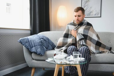 Kışın evde hava soğuktur. Kırık termostat yüzünden kışın evinde donan adam. Oturma odasındaki kanepede otururken yün ekoseye sarılı genç adam titriyor..