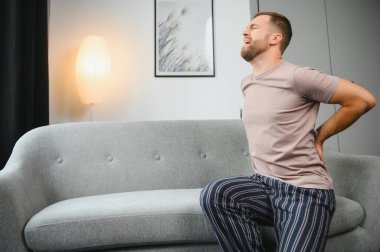 Yakışıklı genç adam evde sırt ağrısı acı
