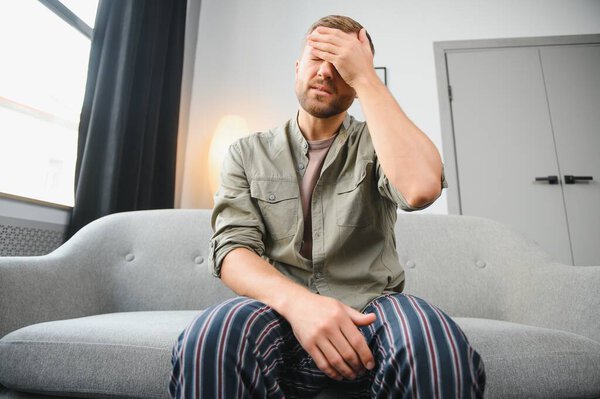 Мужчина с головной болью дома
.