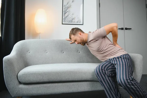 Sırt ağrısı, böbrek iltihabı, evde sırt ağrısı çeken bir adam, sağlık sorunları konsepti.