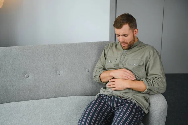 чоловік на дивані, біль