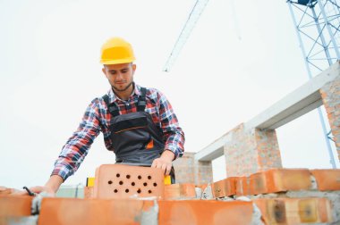 Construction worker in uniform and safety equipment have job on building.
