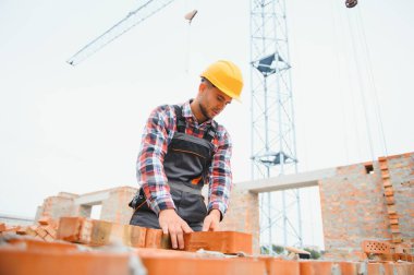 Construction worker in uniform and safety equipment have job on building.