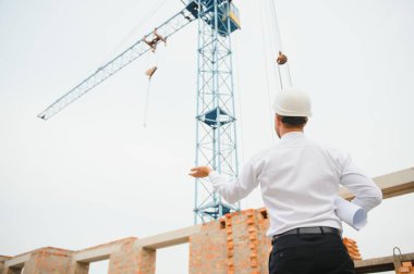 İnşaat alanında mavi baskı ile çalışan mühendis konsepti