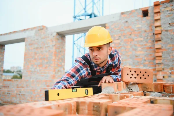 Usando Ladrillos Joven Trabajador Construcción Uniforme Está Ocupado Edificio Sin — Foto de Stock