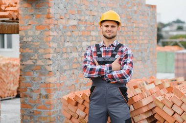 Construction worker in uniform and safety equipment have job on building. Industrial theme.