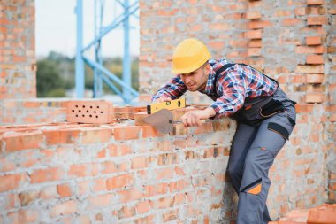 Construction worker in uniform and safety equipment have job on building. Industrial theme.