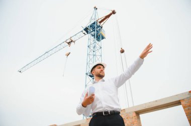 İnşaat alanında mavi baskı ile çalışan mühendis konsepti