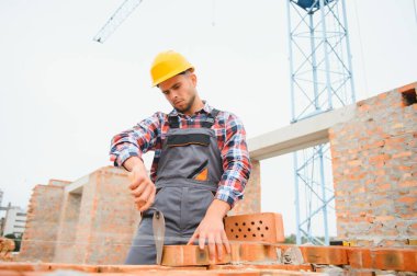 Construction worker in uniform and safety equipment have job on building.