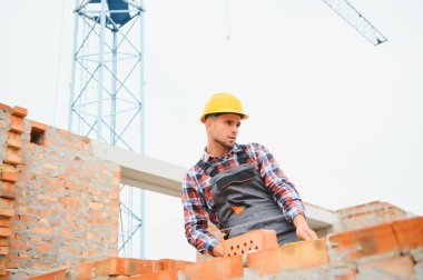 Construction worker in uniform and safety equipment have job on building.