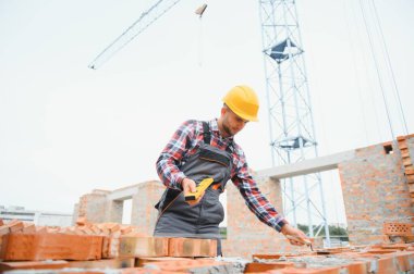 Construction worker in uniform and safety equipment have job on building.