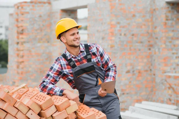 Construction worker in uniform and safety equipment have job on building. Industrial theme.