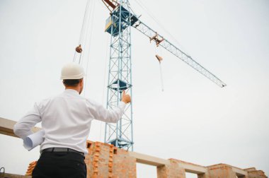 İnşaat alanında mavi baskı ile çalışan mühendis konsepti