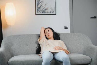 Genç bir kadın yatakta yatıyor ve jinekolojik sorunları, adet sancısı, mide ağrısı ya da karın ağrısı çekiyor. Adet dönemi ya da adet dönemi