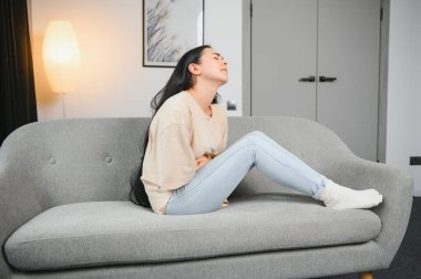 Üzgün, üzgün, çekici bir kadın evdeki kanepede ağlıyor. Yalnız hissediyor, yorgun ve endişeli. Akıl sağlığı, yalnızlık ve yalnızlık yüzünden depresyonda. Psikoloji, yalnızlık ve insanlar