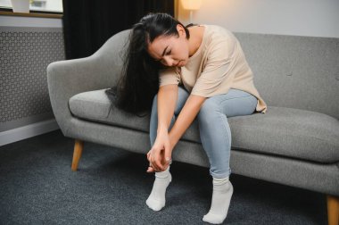 Üzgün, üzgün, çekici bir kadın evdeki kanepede ağlıyor. Yalnız hissediyor, yorgun ve endişeli. Akıl sağlığı, yalnızlık ve yalnızlık yüzünden depresyonda. Psikoloji, yalnızlık ve insanlar