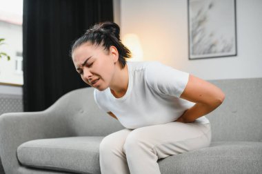 Genç kadın evde karın ağrısı muzdarip. Kadın hastalıkları kavramı.