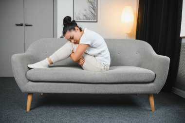 Aylık adet, adet döngüsü günü, genç bir kadın, karın ağrısı çeken bir kadın, adet öncesi, karın ağrısı ya da karın ağrısı çekiyor. Vücuttaki sağlık sorunu iltihaplandı