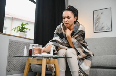 Evde koltukta oturan genç hasta kadın