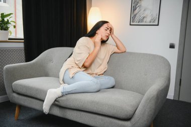 Alnına dokunan üzgün, yorgun, genç bir kadın baş ağrısı ya da depresyon geçiriyor. Sıkıntılı, sıkıntılı bir kız.