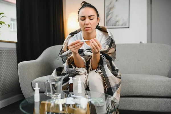 Grip ve grip. Hasta kadın üşütmüş, hasta olmuş. Battaniyeyle kaplanmış, burnunu silen ve termometreye bakan sağlıksız güzel bir kız. Sağlık hizmetleri kavramı