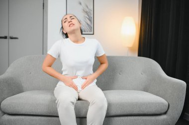 Genç kadın evde karın ağrısı muzdarip. Kadın hastalıkları kavramı.