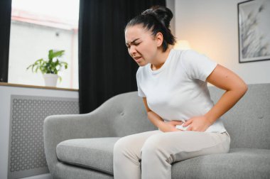 Genç kadın evde menstrüel kramp acı. Kadın hastalıkları.