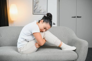 Aylık adet, adet döngüsü günü, genç bir kadın, karın ağrısı çeken bir kadın, adet öncesi, karın ağrısı ya da karın ağrısı çekiyor. Vücuttaki sağlık sorunu iltihaplandı