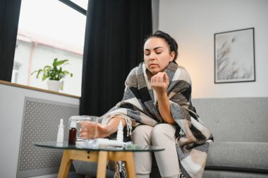 Evde koltukta oturan genç hasta kadın