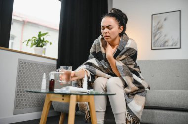 Evde koltukta oturan genç hasta kadın