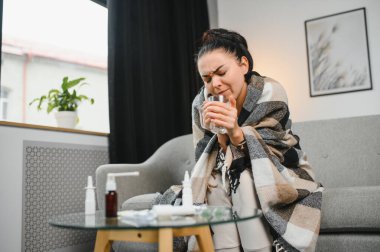 Evde koltukta oturan genç hasta kadın