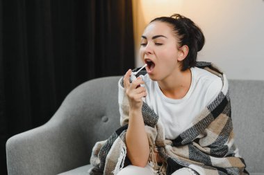 öksürük sprey kullanarak fularlı hasta genç kadın