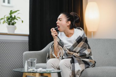 öksürük sprey kullanarak fularlı hasta genç kadın